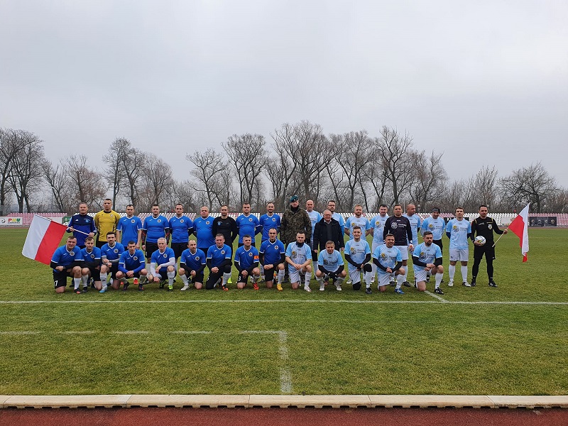 Zdjęcie przedstawiające grupę mężczyzn - zawodników na murawie stadionu