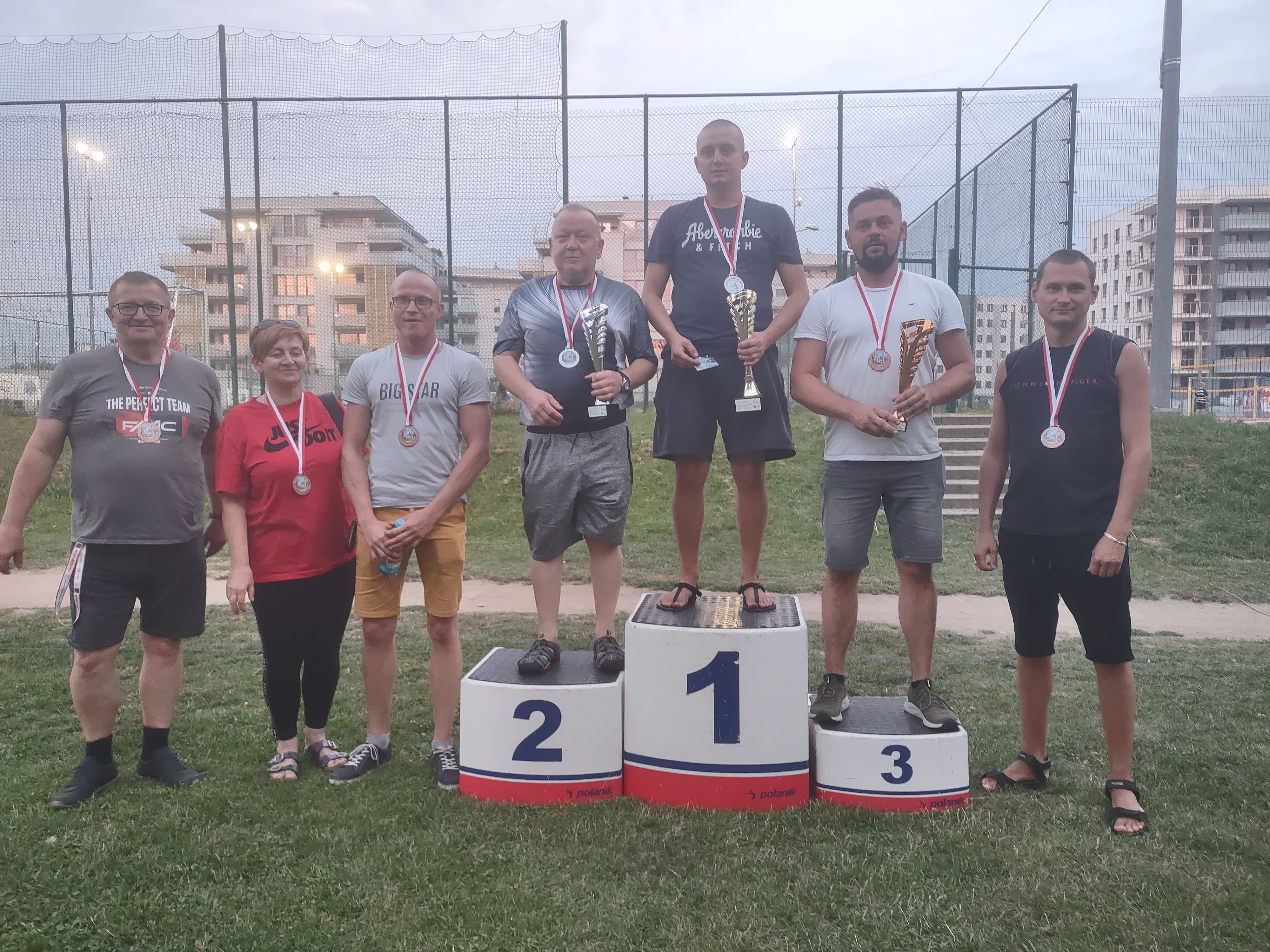 Zwycięzcy III Turnieju Boule stoją na podium, na tle Orlika w Łomży