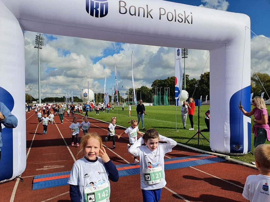 zdjęcie przedstawiające dzieci biegnące po bieżni na stadionie