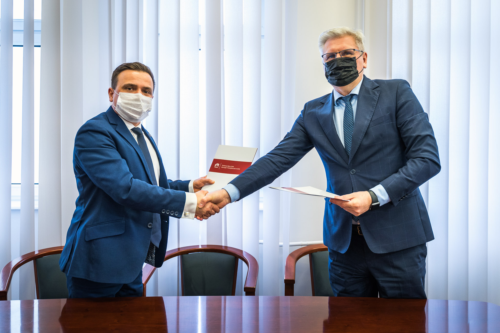 Zdjęcie przedstawia Dyrektora MOSiR i Rektora PWSIiP podających sobie dłonie.