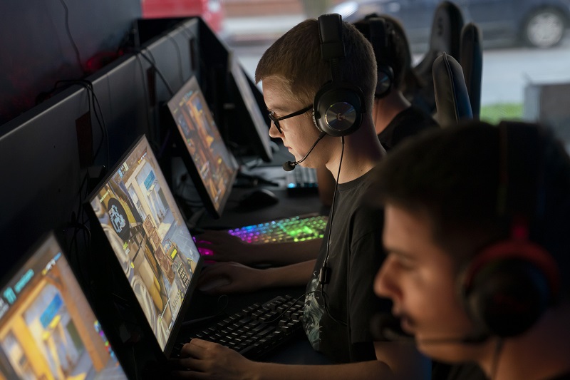zdjęcie mężczyźni przed monitorami grający w gry komputerowe