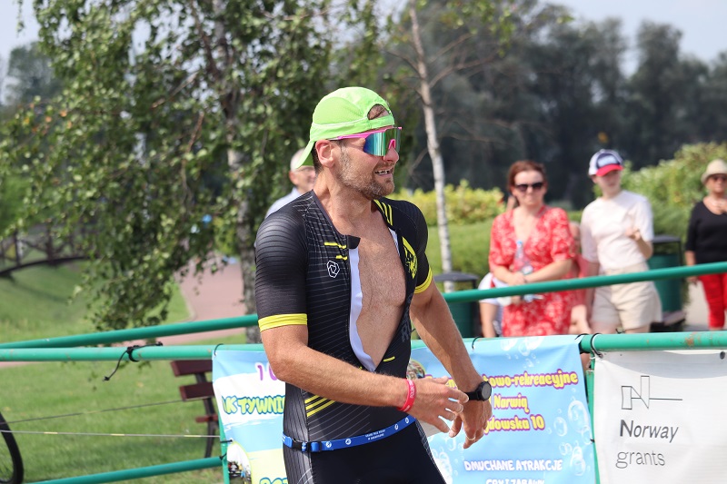 zdjęcie przedstawiające zawodników triathlonu na bulwarach, w tle kibice