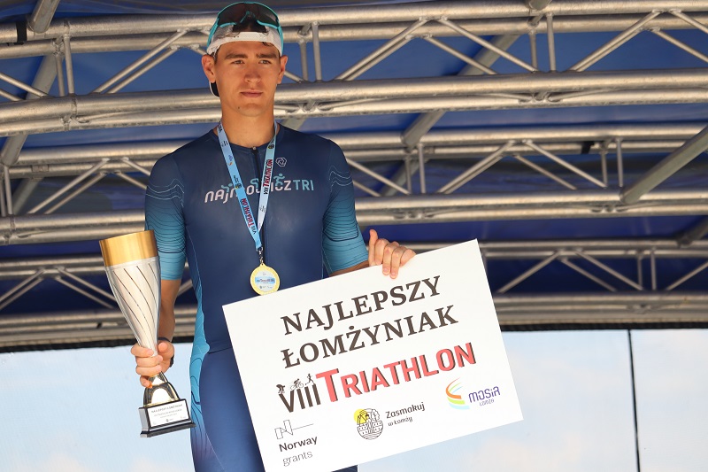 zdjęcie przedstawiające zwycięzców triathlonu na podium na scenie