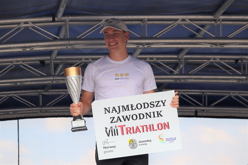 zdjęcie przedstawiające zwycięzców triathlonu na podium na scenie