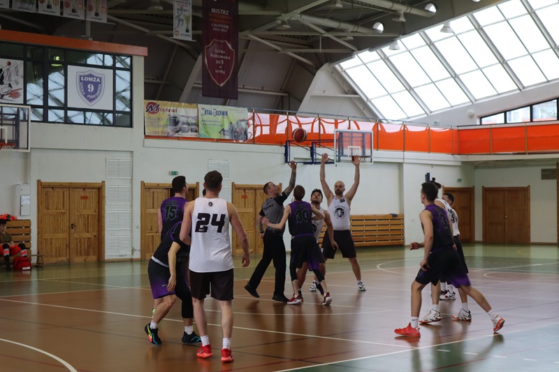 Zdjęcie przedstawia zawodników grających w koszykówkę na Hali Sportowej.