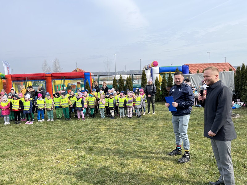 Prezydent Miasta na pierwszym planie, a w tle dzieci i dmuchańce