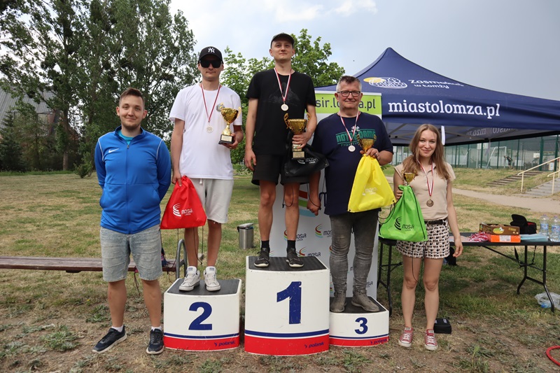 Zdjęcie przedstawia zwycięzców Turnieju w Boule. Wszyscy mają puchary i stoją na lub obok podium.