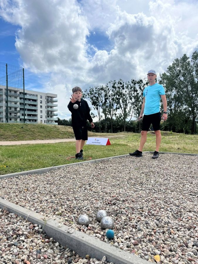 Szymon Walczyk rzucający kulą boule, obok inny zawodnik