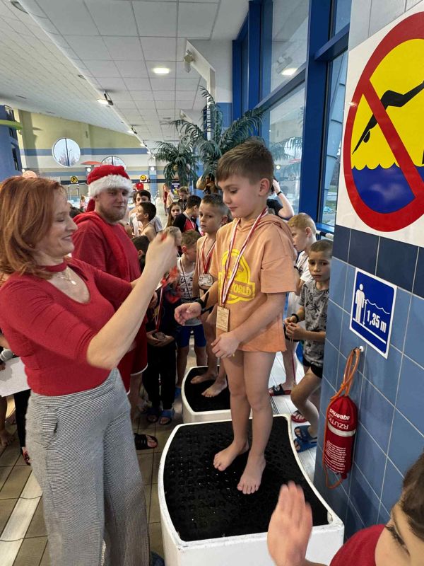 Pani dyrektor Bernadeta Krynicka wręczająca medale grupie zawodników