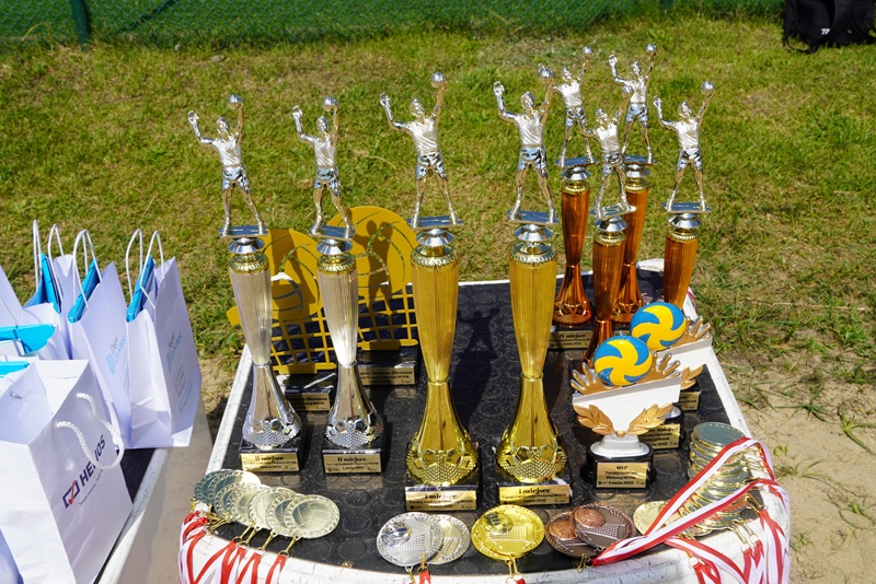 Zdjęcie przedstawia Trofea sportowe stojące na podium.