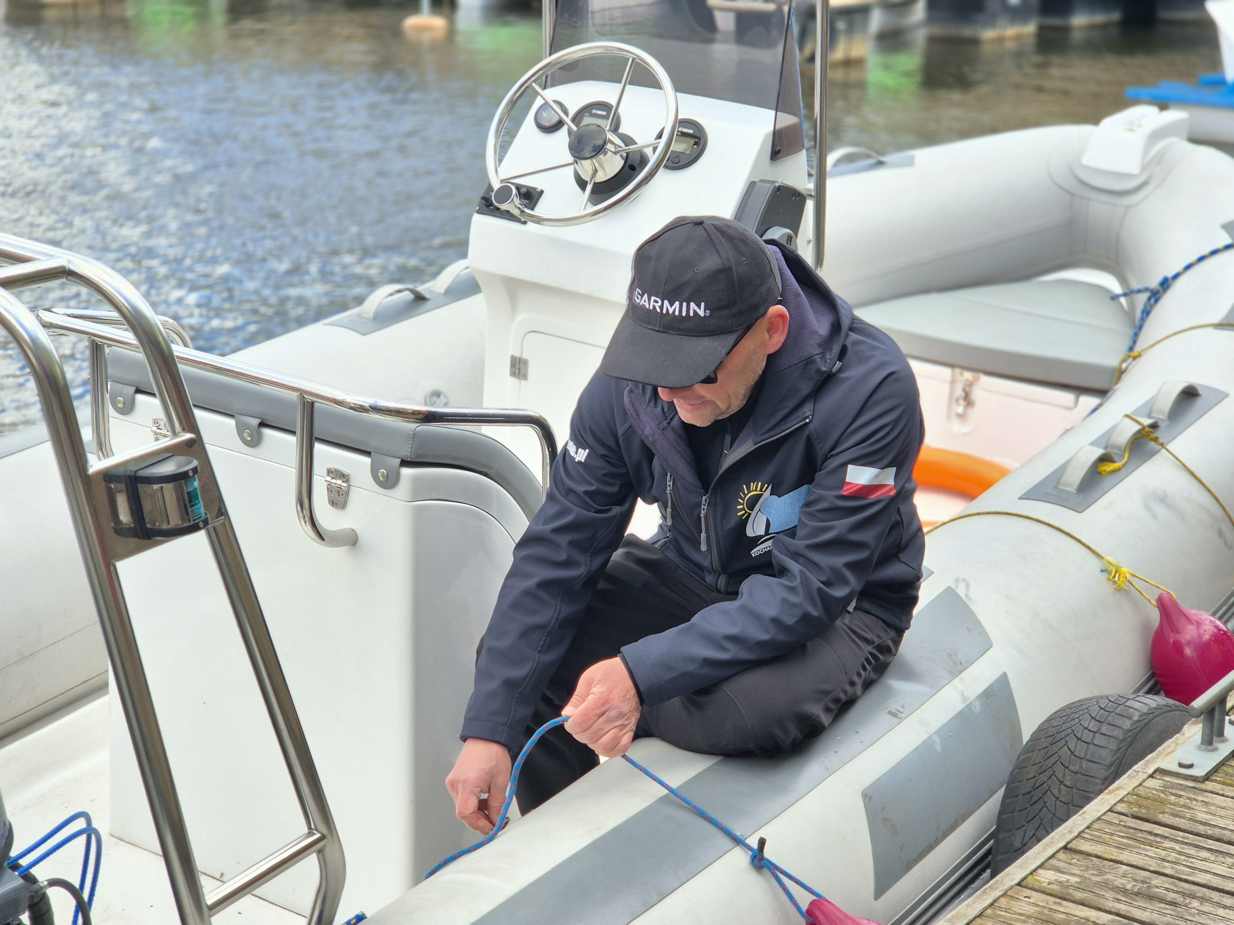 zdjęcie mężczyzny na motorówce na tle wody w porcie rzecznym