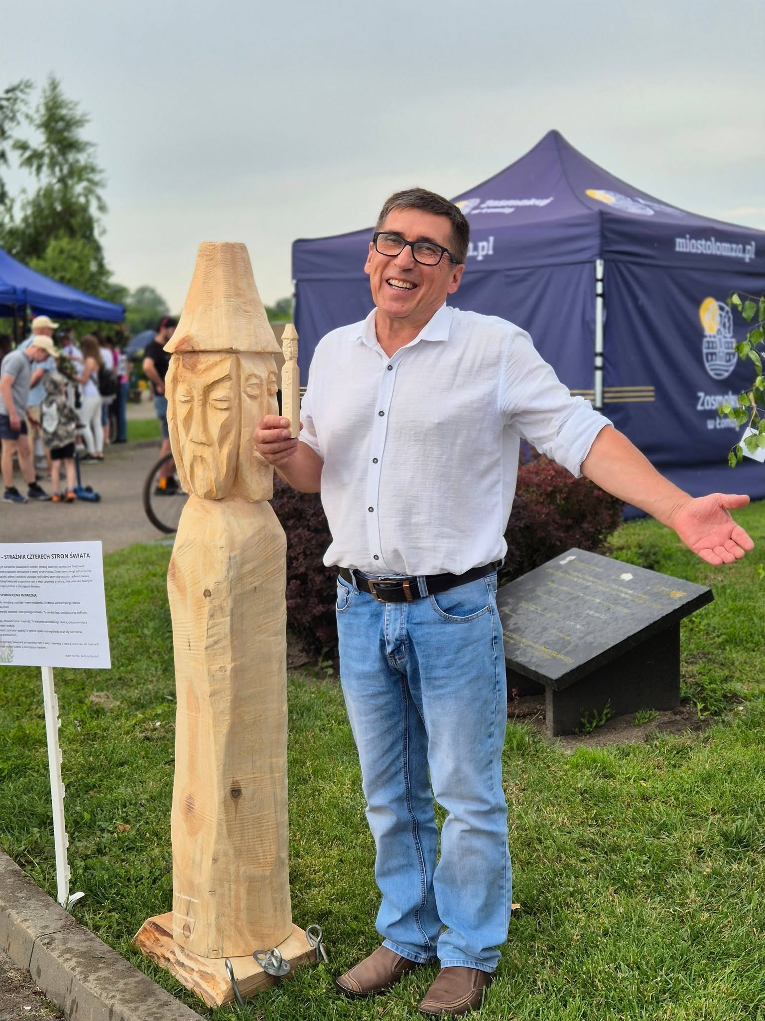 Andrzej Banach z rzeżbą Świetowida, w tle uczestniczy wydarzenia na bulwarach